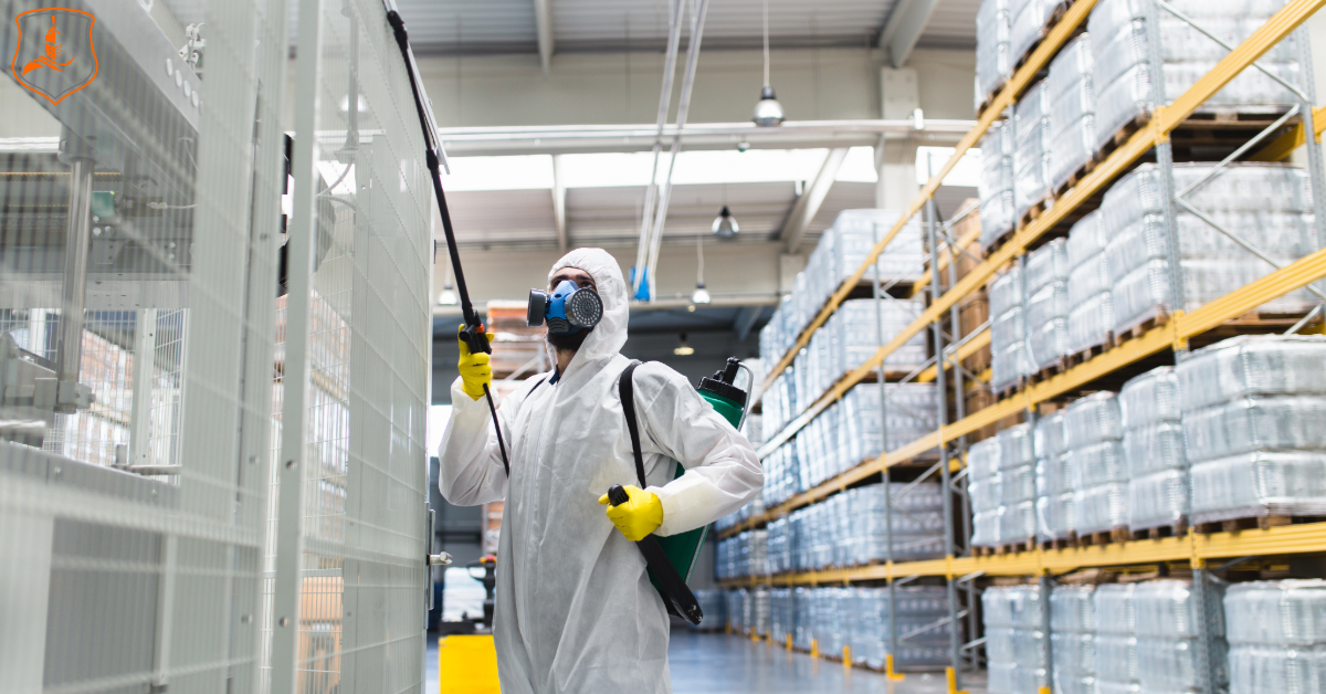 Commercial pesticide applicator wearing protective gear spraying inside a Texas warehouse, representing EIS-Texas commercial pesticide insurance.